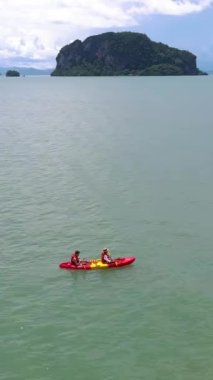 a couple of men and women in a kayak at the mangrove forest in Phuket Thailand. men and women paddling in a kayak during vacation