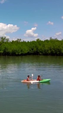 couple in a kayak at the mangrove forest in Phuket Thailand. men and women paddling in a kayak during vacation
