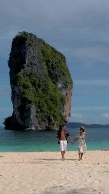 couple men and women on a tropical white beach in Thailand, Koh Poda Island Krabi during summer vacation in Thailand