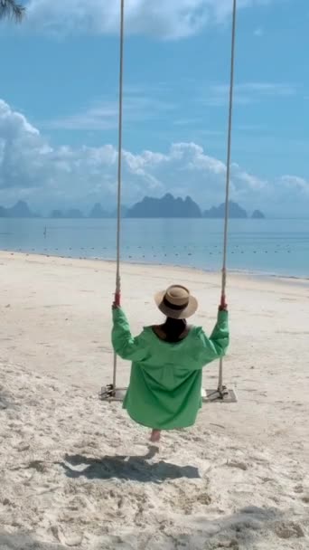 プーケットのビーチでのスイングでアジアのタイ人女性タイ 休暇中に熱帯ビーチでリラックスした女の子 — ストック動画