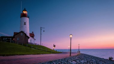 Urk Flevoland Netherlands sunset at the lighthouse and harbor of Urk Holland. Traditional Fishing village Urk. Beautiful sunset during the evening