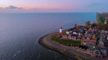 Drone view at Urk Flevoland Netherlands sunset at the lighthouse and harbor of Urk Holland. Fishing village Urk. Beautiful sunset during the evening