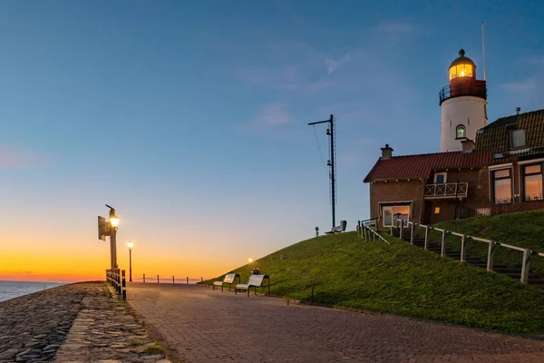 Urk Flevoland Netherlands sunset at the lighthouse and harbor of Urk Holland. Traditional Fishing village Urk. Beautiful sunset during the evening