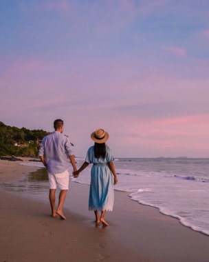 a couple of men and women looking at sunset on the beach of Koh Lanta Krabi Thailand. Kantiang Bay Koh Lanta
