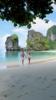 couple of men and women on a tropical white beach in Thailand, Koh Hong Island Krabi during summer vacation in Southern Thailand