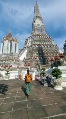 Couple at Wat Arun temple in Bangkok Thailand during sunset.