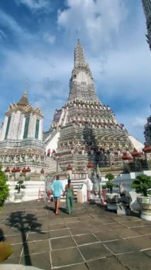 Couple at Wat Arun temple in Bangkok Thailand during sunset.