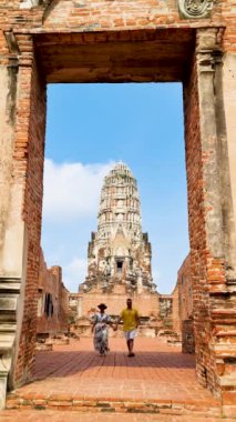 A Couple of Asian women and European men visit the ruins and Pagodas at Wat Mahathat Temple of Ayutthaya Province. Ayutthaya Historical Park, Thailand. 