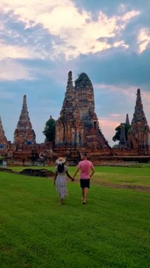 A Couple of Asian women and European men looking at the ruins and Pagodas at Wat Mahathat Temple of Ayutthaya Province. Ayutthaya Historical Park, Thailand during sunset