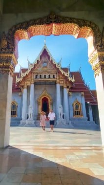 A couple of men and women visit Wat Benchamabophit temple in Bangkok Thailand, The Marble temple in Bangkok. 