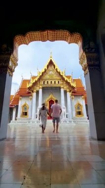 A couple of men and women visit Wat Benchamabophit temple in Bangkok Thailand, tourists visit The Marble temple in Bangkok. 