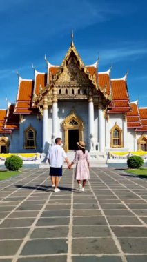 A couple of men and women visit Wat Benchamabophit temple in Bangkok Thailand, The Marble temple in Bangkok. 
