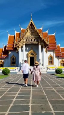 A couple of men and women visit Wat Benchamabophit temple in Bangkok Thailand, The Marble temple in Bangkok. 