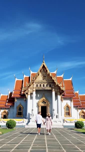 男性と女性のカップルがバンコクのワット ベンチャマボフィット寺院を訪問タイ 観光客はバンコクの大理石寺院を訪問 — ストック動画