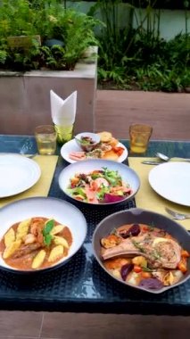 Table with dinner Thai food and seafood with a pork ribeye steak with salad