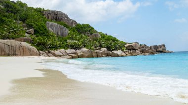 Tropical beach with huge boulders and palm trees Coco Island Tropical Seychelles Islands. 