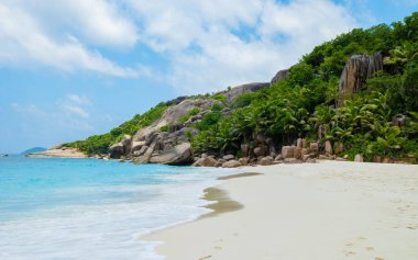 Tropical beach with huge boulders and palm trees Coco Island Tropical Seychelles Islands. 