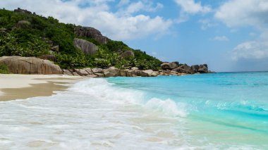 white tropical beach with huge boulders and palm trees Coco Island Tropical Seychelles Islands on a sunny day