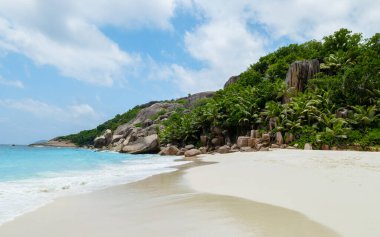 white tropical beach with huge boulders and palm trees Coco Island Tropical Seychelles Islands on a sunny day