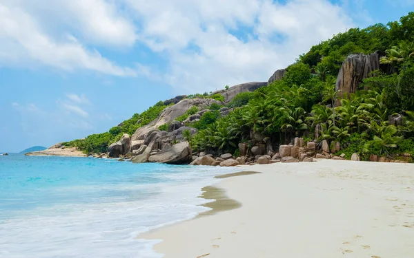 Tropical beach with huge boulders and palm trees Coco Island Tropical Seychelles Islands. 