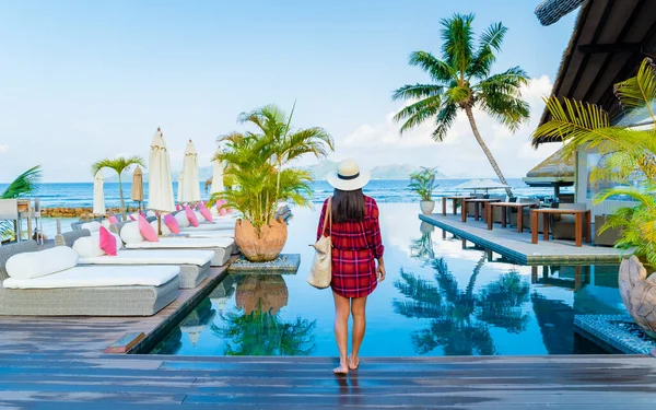 豪華なホテル サンベッド 傘のスイミングプールでアジアの女性 — ストック写真