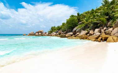 A white tropical beach with turquoise colored ocean Grand Anse Beach La Digue Seychelles Islands. 