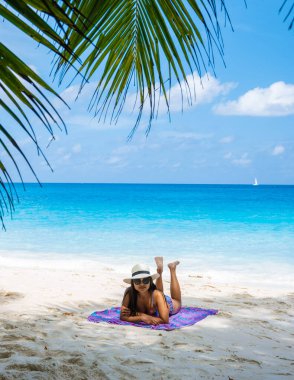 Young Asian woman with a hat at a white tropical beach Anse Lazio beach Praslin Tropical Seychelles Islands. 