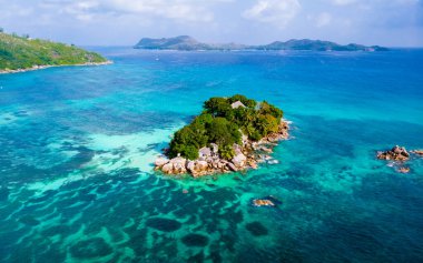 Drone view from above at a tropical beach in Seychelles. Anse Volbert beach Praslin with granite boulders rocks