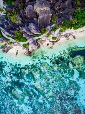 Drone view from above at a tropical beach in the Seychelles, Anse Source dArgent white tropical beach with huge granite boulders at La Digue Island
