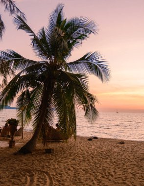 sunset on the beach of Pattaya Thailand in the evening with palm trees