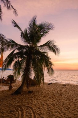 sunset on the beach of Pattaya Thailand in the evening with palm trees