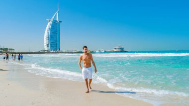 Young man in a swim short on the beach in Dubai, Jumeirah beach Dubai United Arab Emirates on a sunny day. 