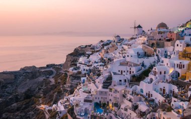 Sunset at the village of Oia Santorini Greece during summer with whitewashed homes and churches, Greek Island Aegean Cyclades