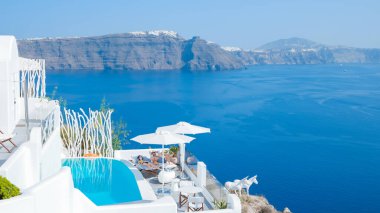 Vacation at Santorini swimming pool looking out over the Caldera ocean of Santorini, Oia Greece, Greek Island Aegean Cyclades September 2017
