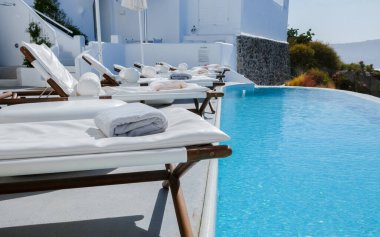 Vacation at Santorini swimming pool looking out over the Caldera ocean of Santorini, Oia Greece, Greek Island Aegean Cyclades. 