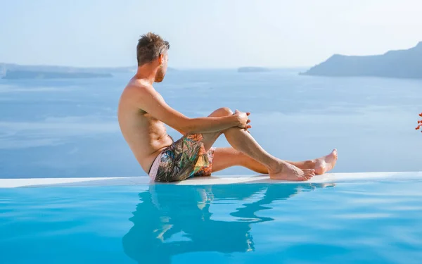 Mężczyzna Relaksujący Się Nieskończoność Podczas Wakacji Santorini Basen Widokiem Ocean — Zdjęcie stockowe