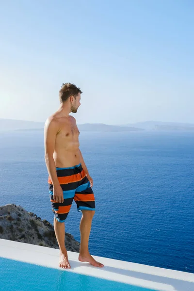 Mężczyzna Relaksujący Się Nieskończoność Podczas Wakacji Santorini Basen Widokiem Ocean — Zdjęcie stockowe