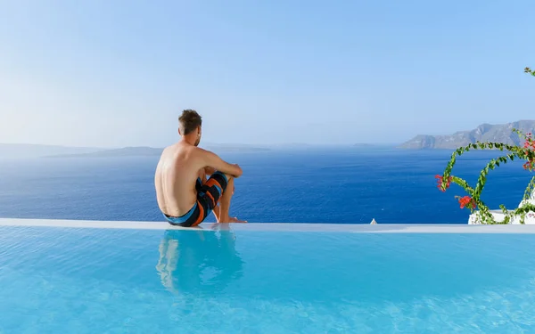 Mężczyźni Relaksujący Się Basenie Infinity Podczas Wakacji Santorini Basen Widokiem — Zdjęcie stockowe