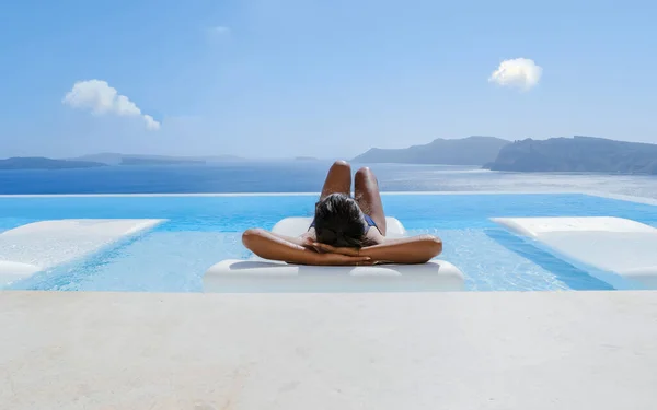 サントリーニ島での休暇中の若いアジアの女性サントリーニ島 オアギリシャ ギリシャ島のカルデラ海を見下ろすスイミングプールエーゲ海のキクラデス — ストック写真