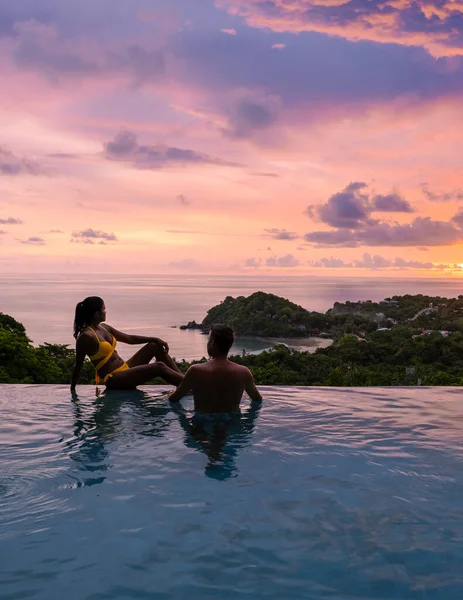 Günbatımında Tropikal Bir Adada Yüzme Havuzunda Bir Çift Genç Erkek — Stok fotoğraf