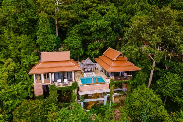 couple of men and women on a luxury vacation at a pool villa in the jungle rainforest.