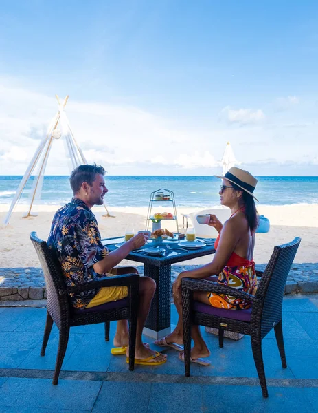 Luxury breakfast on the beach of Phuket Thailand, couple having breakfast outdoor on the beach.