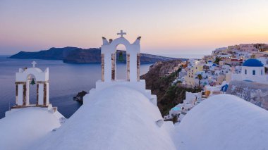 White churches an blue domes by the ocean of Oia Santorini Greece, a traditional Greek village in Santorini during summer