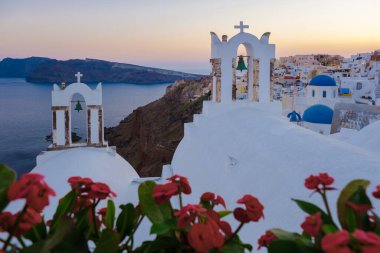White churches an blue domes by the ocean of Oia Santorini Greece, a traditional Greek village in Santorini during summer
