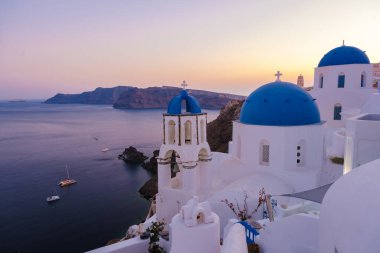 White churches an blue domes by the ocean of Oia Santorini Greece, a traditional Greek village in Santorini. 