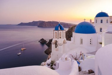 White churches an blue domes by the ocean of Oia Santorini Greece, a traditional Greek village in Santorini during summer