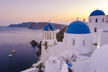 White churches an blue domes by the ocean of Oia Santorini Greece, a traditional Greek village in Santorini. 
