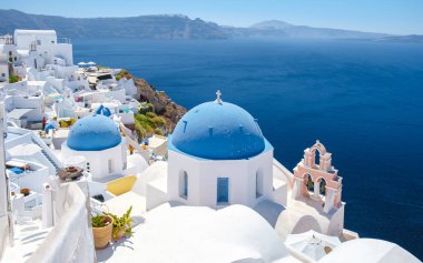 White churches and blue domes by the ocean of Oia Santorini Greece, a traditional Greek village in Santorini in the evening light