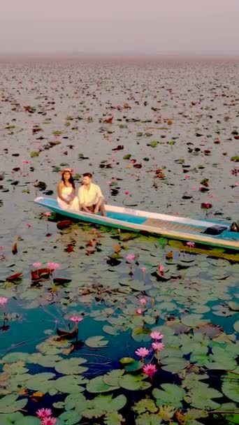 位于泰国乌顿萨尼农哈恩湖红莲海的日出 在泰国红莲湖畔的日出时分 男人和女人坐在木船上 — 图库视频影像