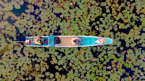 赤い蓮の海での日の出 ハーン湖 うどんタイ タイの赤い蓮の湖で日の出の間に木製のボートの男性と女性のカップル — ストック動画